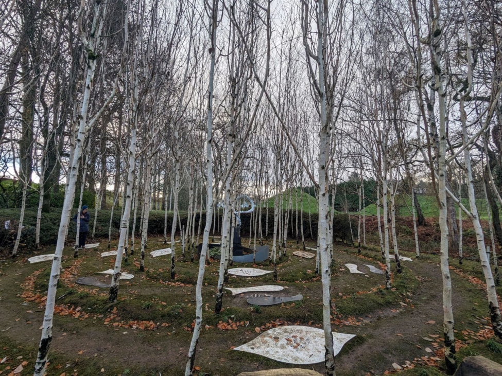a grove of trees and a labyrinth at the garden of cosmic speculation