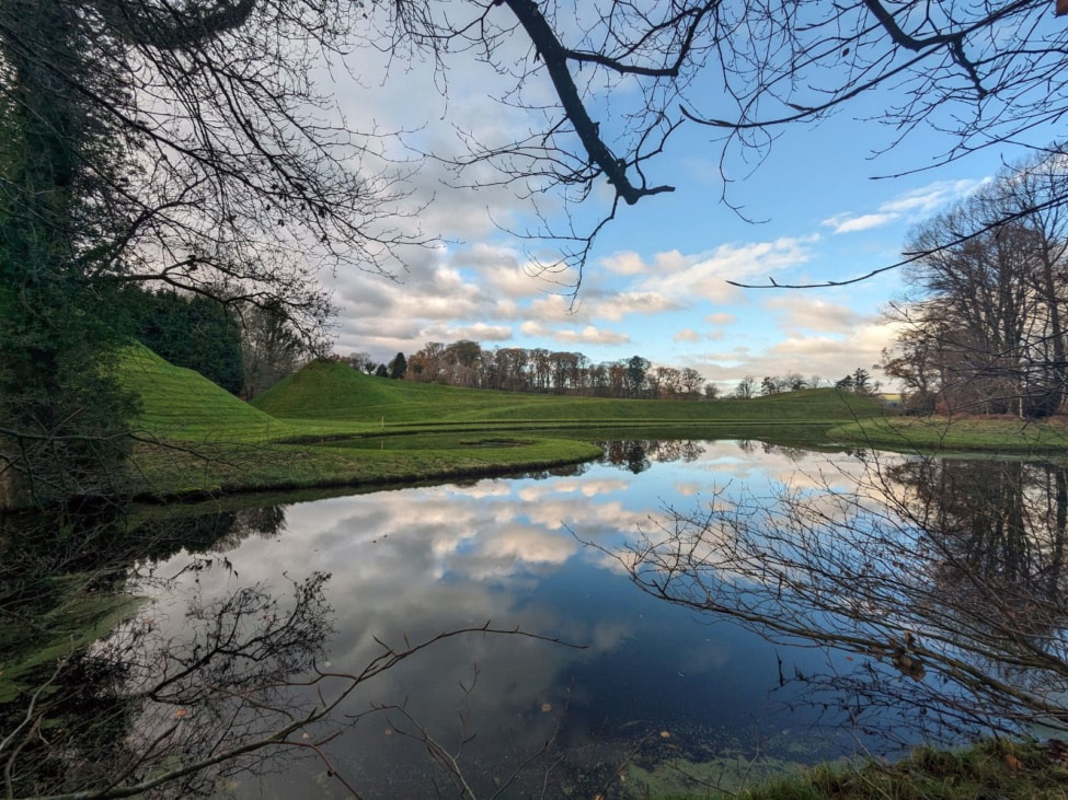 clouds reflected in a lake at the Garden of Cosmic Speculation