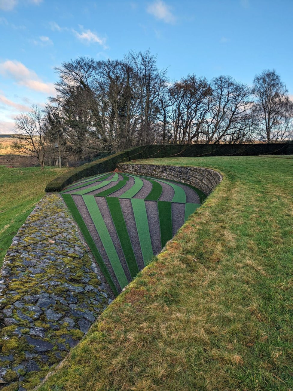 twisted planes planted with stripes of plants at the garden of cosmic speculation